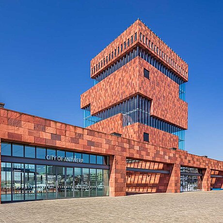 [Translate to Swiss German:] Modernes Gebäude mit roter Steinfassade.