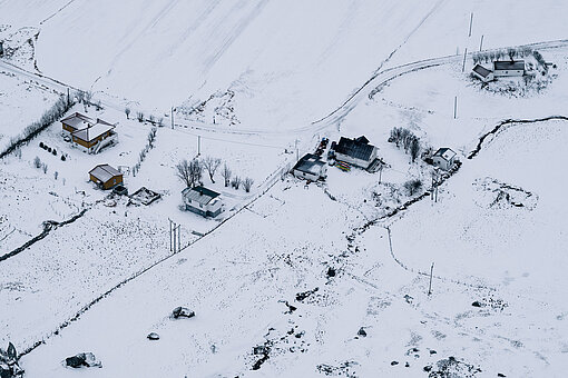 Des maisons et des champs couverts de neige.