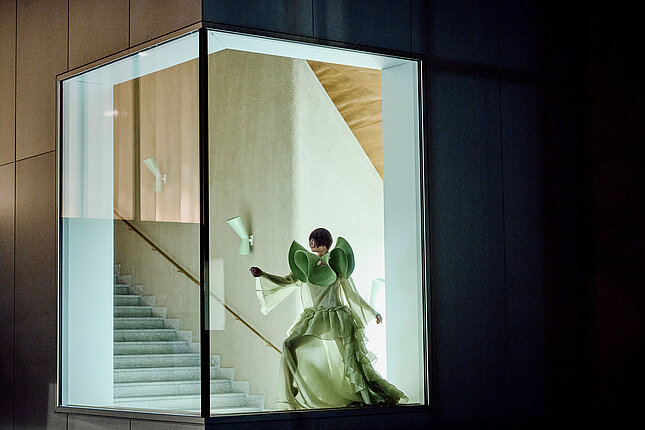 Tänzerin hinter einem bodentiefen Fenster.